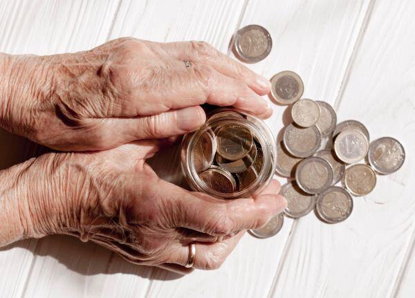 Mujer anciana con monedas en un frasco