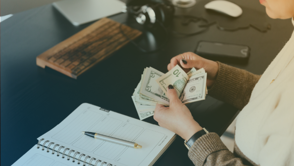 una persona contando billetes de dolar 